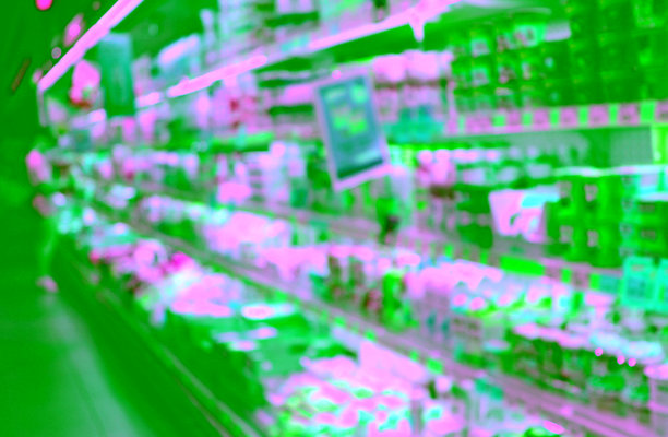 模糊的女性照片，在杂货店的冰箱和货架前，摆放着牛奶商品图片下载