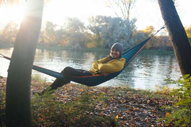 男人躺在吊床中享受阳光，自然风光素材图片下载