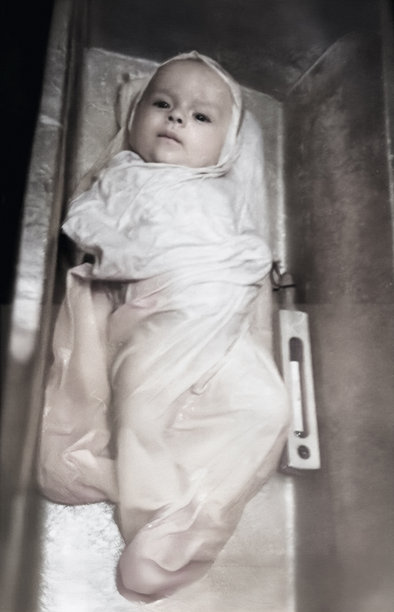 一张复古风格的婴儿肖像照，拍摄于1961年，照片中一名男婴正在浴缸里洗澡，旁边放着温度计。图片下载