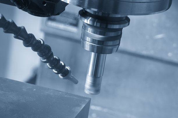 在浅蓝色背景下，数控铣床使用可转位刀具粗加工模具零件。图片下载