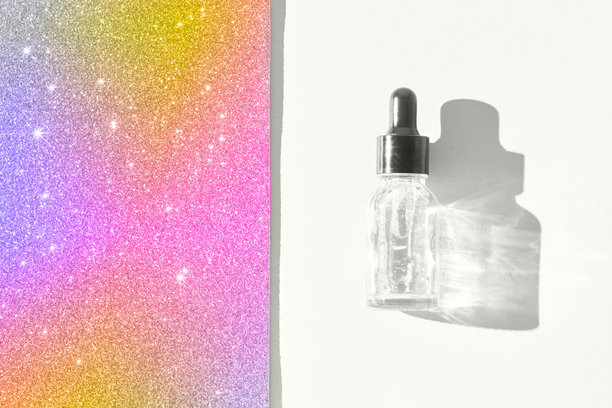 滴管式透明化妆品精华液瓶子，在白色表面上投下阴影，旁边有五彩闪光。图片下载