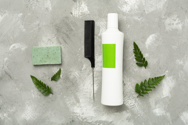 洗发水和发膜，背景为绿色叶子和混凝土，俯视图图片下载
