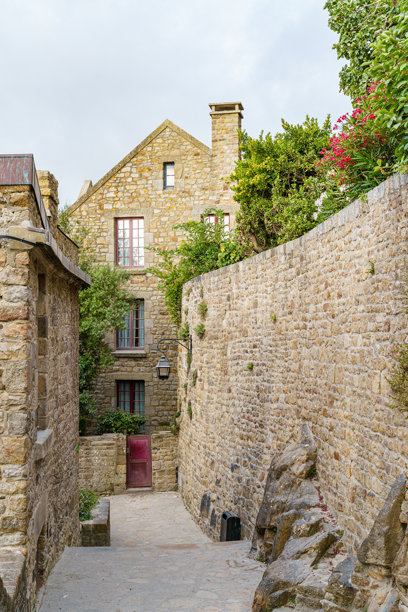 法国圣米歇尔山的城堡墙上，石头建筑旁一条舒适的街道，傍晚拍摄的照片图片下载