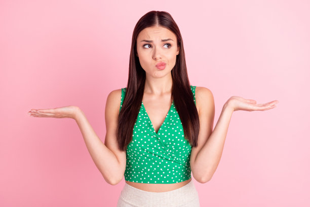照片肖像：一位女性耸肩表示不知道，背景是粉彩粉红色图片下载