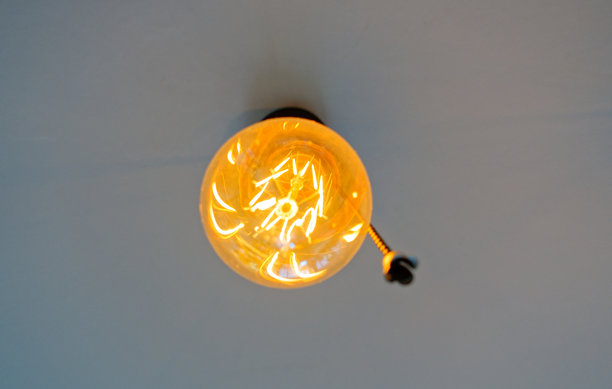 发光的复古爱迪生灯泡悬挂在白色天花板上图片下载