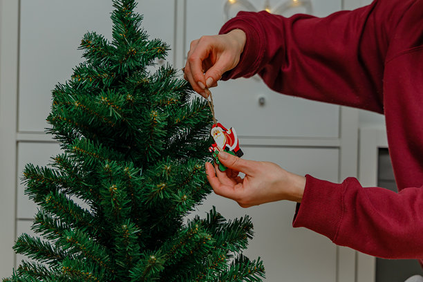 女孩穿着舒适的居家服装饰圣诞树图片下载