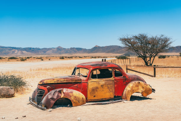 荒漠景观中废弃的复古汽车残骸图片下载