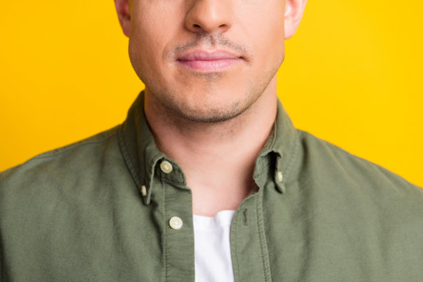 特写照片，年轻英俊的男人嘴唇护肤乳液润唇膏理发店，隔离在黄色背景上图片下载