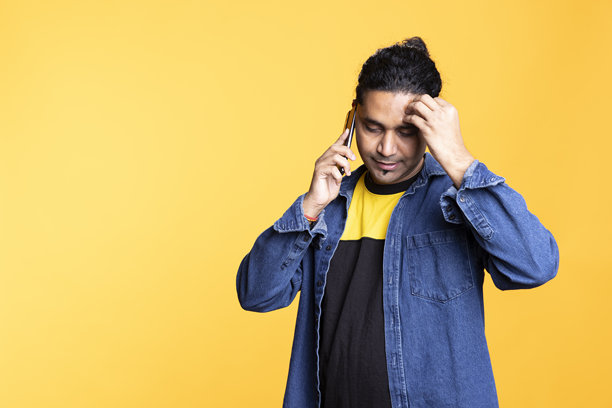 一个友善的梳着丸子头的男人正在打电话给他的朋友八卦图片下载