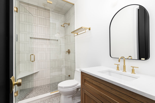 一个带木制橱柜、金色水龙头和步入式淋浴间的豪华浴室。图片下载