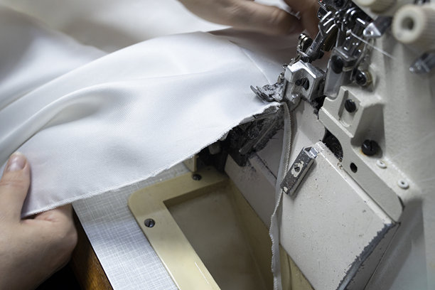 设计师正在锁边机上缝制婚纱的素材照片图片下载
