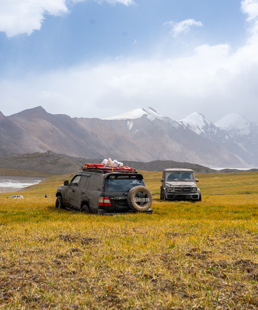 越野车在山地平原的河边聚集图片下载