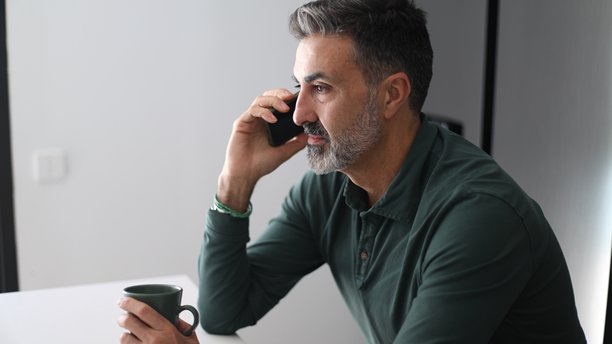 男人一边拿着咖啡杯一边打电话图片下载