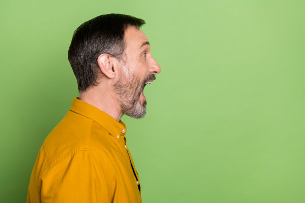 帅气男子的侧面照片，望向空白处，大喊，新闻资讯，隔离在绿色背景上图片下载