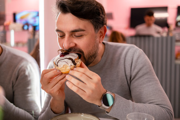 在舒适的咖啡馆享用美味的甜甜圈，上面有巧克力和浆果配料图片下载