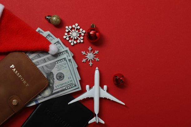 圣诞节旅行。护照、金钱、礼物图片在红色背景上的俯视图，有设计空间。图片下载