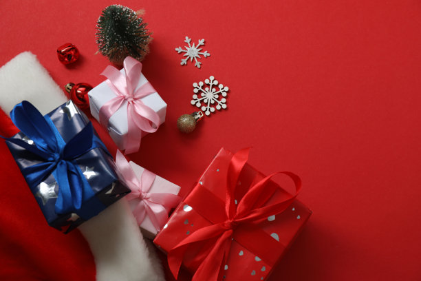 圣诞旅行。护照、金钱、礼物图片俯视图，背景为红色，留有设计空间。图片下载