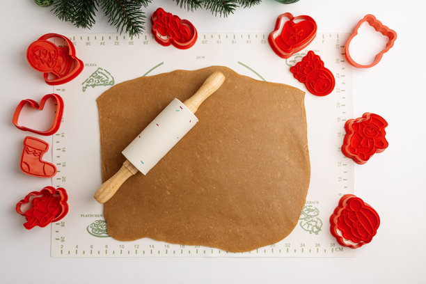 圣诞节日曲奇饼干面团，配有饼干模具和擀面杖，放在烘焙垫上图片下载