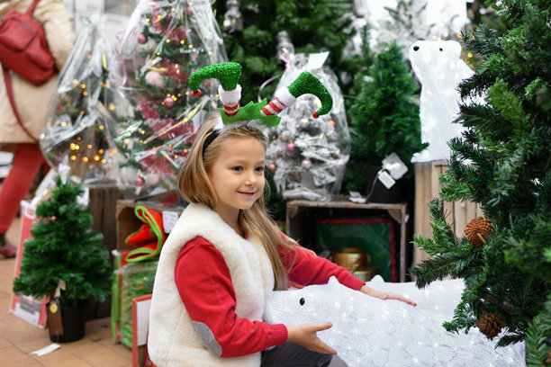 一个戴着发带的女孩，有着小丑般倒置的双腿，置身于圣诞商店中图片下载