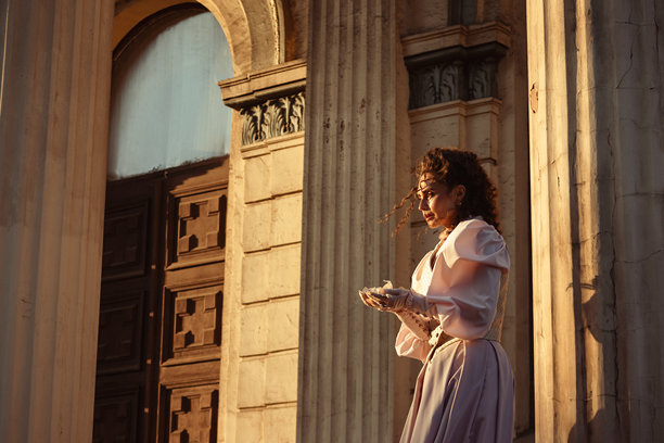 一位身着复古连衣裙的女士，手持一封撕破的信件，脸上带着失望的神情图片下载