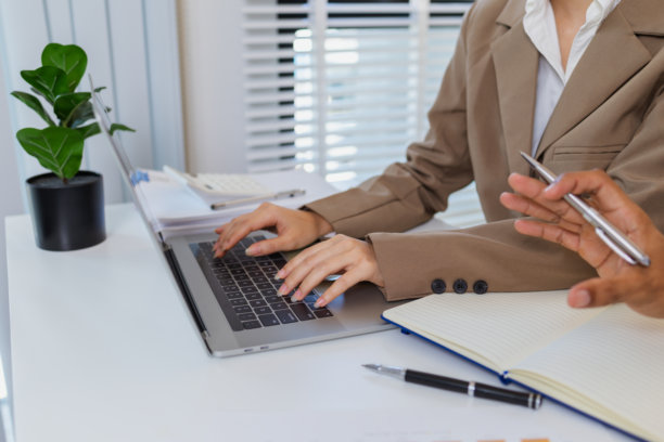 女商人在办公室用笔记本电脑工作。这张图片代表了在现代商业环境中专注、专业和高效。图片下载