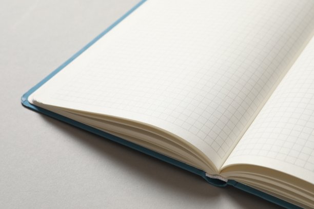 俯视拍摄的笔记本照片，背景为浅色，留有空白区域。商业概念图片下载