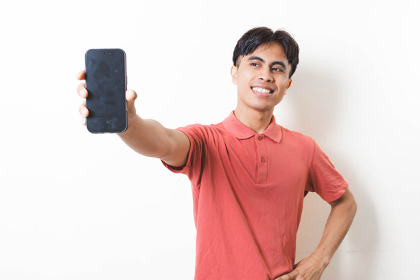 面带微笑的男子展示空白的智能手机屏幕，适用于应用推广、数字服务展示或产品广告，背景干净。图片下载