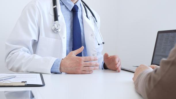 医生在临床咨询中，在笔记本电脑屏幕上与患者一起审阅数字化的检测结果，讨论健康状况。医学与医疗保健概念。图片下载