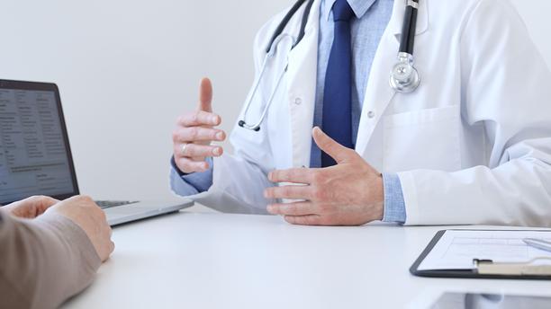 医生在临床咨询中，在笔记本电脑屏幕上与患者一起审阅数字化的检测结果，讨论健康发现。医学与医疗保健概念图片下载