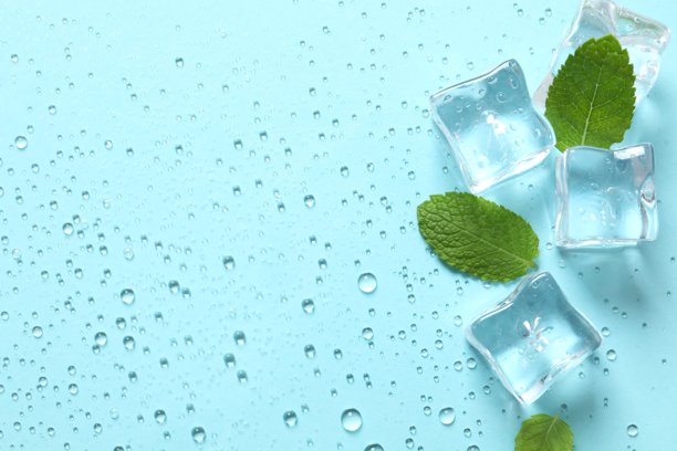 俯视角度拍摄的薄荷叶、冰块和水滴在粉蓝色背景上的照片图片下载