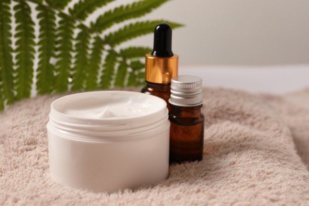 黄色背景上的天然化妆品面霜或身体乳罐，搭配精华液。源自草本和植物的天然生物化妆品，呵护肌肤。图片下载