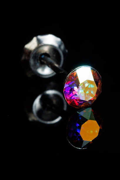 带有宝石的银耳环特写照片，背景为黑色孤立背景。焦点选择。图片下载