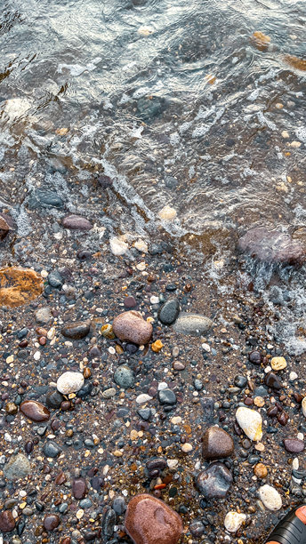 一张捕捉了潮湿鹅卵石海滩美丽自然纹理的照片图片下载