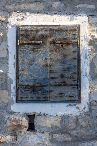 龟裂石墙上的风化木门板，营造出质朴复古的外部外观图片下载
