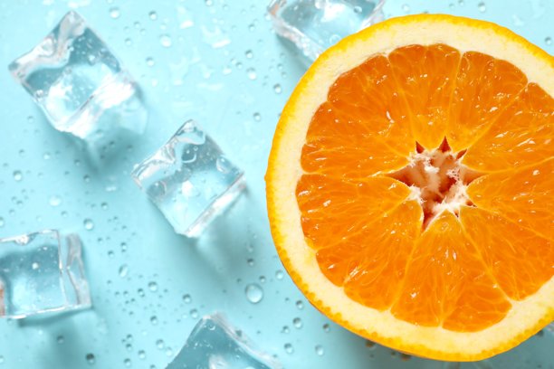 俯视角度拍摄的切片橙子、冰块和水滴在粉蓝色背景上的照片图片下载