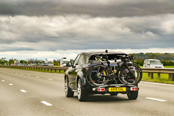 汽车在高速公路上行驶，车顶载有山地自行车图片下载