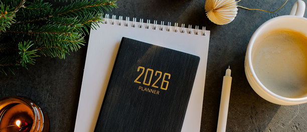 时尚的办公桌布置，摆放着2026年计划本、笔记本、铅笔、眼镜、冷杉枝和咖啡，置于木质表面上。用于设计、网站的横幅图片。图片下载