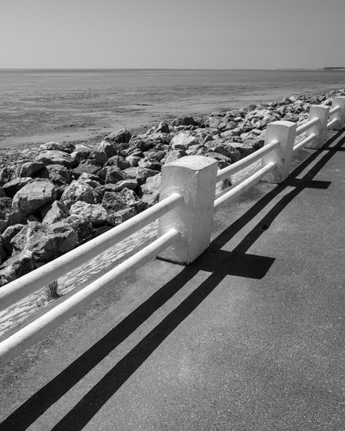 法国北部勒克鲁瓦西海岸公路上的白色栏杆，灰度照片图片下载