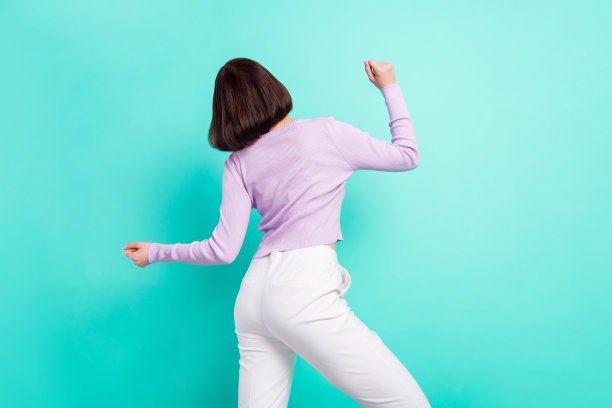 罕见的派对照片：年轻女孩身穿休闲服，在充满活力的蓝绿色背景前翩翩起舞，人物被单独抠出。图片下载