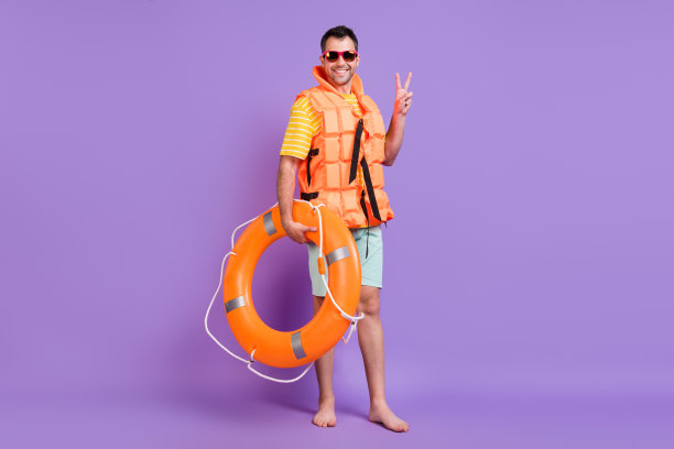 身穿休闲服饰、戴着马甲的快乐积极男士，打着V手势，手持戒指，身着背心，在紫色背景前度假，全尺寸照片图片下载