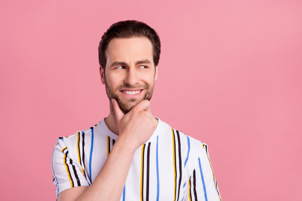 穿着白色T恤、眼神空洞地望着远方的黑发年轻男子的照片，背景为粉色。图片下载