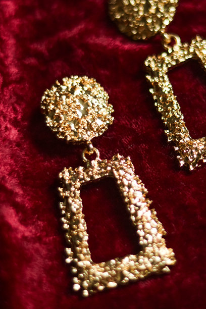 华丽的金色纹理垂坠耳环，搭配深红色天鹅绒，散发出复古奢华的时尚配饰魅力图片下载