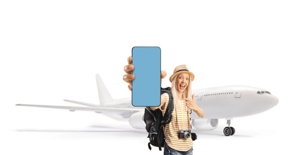 一位快乐的女性游客背着背包，在机场用手指着手机屏幕图片下载