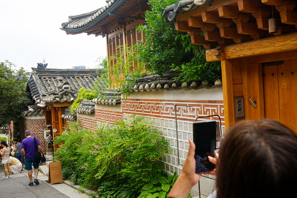 一位游客在韩国首尔用手机拍摄北村韩屋村的照片图片下载