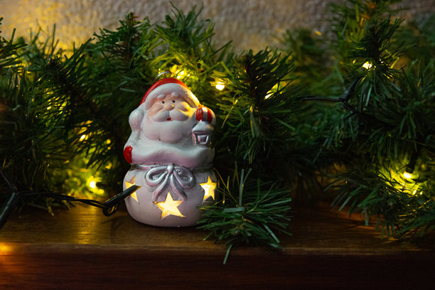 复古圣诞老人灯饰挂件，置于发光的松枝之间图片下载