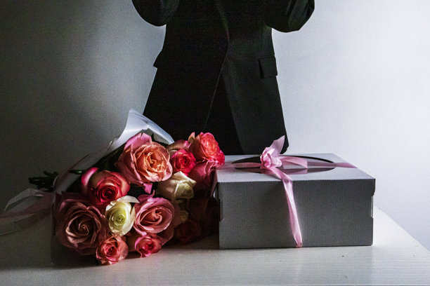 粉色玫瑰花束，旁边是一个节日主题的粉色蛋糕，背景浅色。妇女节，祝贺。图片下载