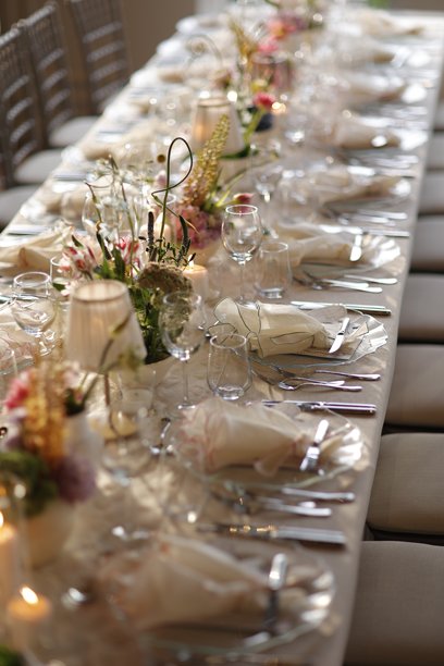 优雅的婚礼接待桌，配有鲜花中心装饰和烛光。素材图片图片下载