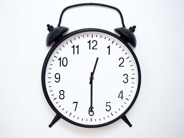 白色木质背景上的黑色复古闹钟，显示00:30或12:30，经典铃铛款式。图片下载