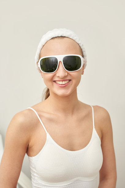 戴着太阳镜和发带，穿着休闲服的年轻白人女性面带微笑图片下载