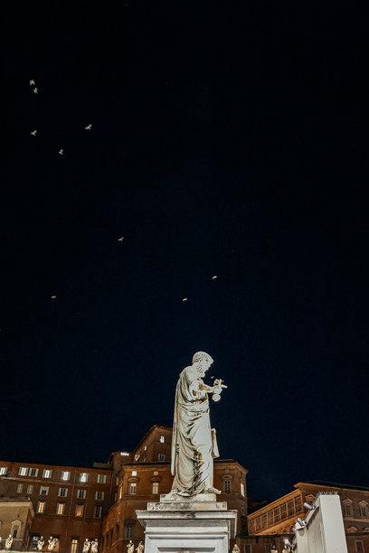 梵蒂冈城、罗马、意大利，圣彼得大教堂前的圣彼得雕像，背景为夜空。竖幅照片图片下载